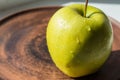 Green apple on a plate in the sun Royalty Free Stock Photo