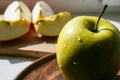 Green apple on a plate in the sun Royalty Free Stock Photo
