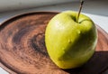 Green apple on a plate in the sun Royalty Free Stock Photo