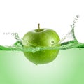 A Green Apple Plunges into a Liquid, Likely Water, Generating Dynamic Splashes Royalty Free Stock Photo