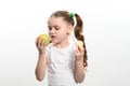 Green apple and potato chips, healthy and unhealthy food for kids, little girl chooses apple over chips. Royalty Free Stock Photo