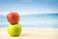 Green apple and red apples on a table,Beach background. Royalty Free Stock Photo