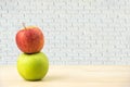 Green apple and red apples on wooden tables,white brick walls ba