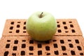 Green apple on red brick stone