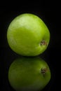 Green apple with reflection on a black background. Vertical image Royalty Free Stock Photo