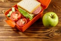 Green apple and school lunch box with sandwich and fresh vegetables Royalty Free Stock Photo