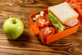 Green apple and school lunch box with sandwich and fresh vegetables Royalty Free Stock Photo