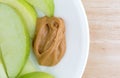 Green apple slices on dish with peanut butter table top Royalty Free Stock Photo