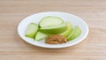 Green apple slices on dish with peanut butter table top Royalty Free Stock Photo