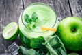 Green apple smoothie in glass and kale leaves on wooden table Royalty Free Stock Photo