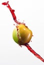 Green apple and splash of red juice on white background. Royalty Free Stock Photo
