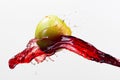 Green apple and splash of red juice on white background. Royalty Free Stock Photo