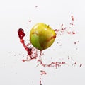 Green apple and splash of red juice on white background. Royalty Free Stock Photo