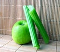 The green apple with two slices of the celery Royalty Free Stock Photo