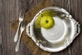 Green apple on vintage plate with two folks