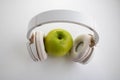 Green apple in which headphones are connected. The music player in the shape of an apple with headphones.Fantasy on the theme of Royalty Free Stock Photo