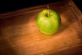 Green apple on a wooden tray