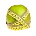 Green apple wrapped with yellow measurement tape.