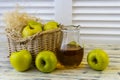 Green apples, basket with apples and jug with apple juice on wooden background Royalty Free Stock Photo