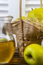 Green apples, basket with apples and jug with apple juice on wooden background Royalty Free Stock Photo