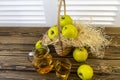 Green apples, basket with apples and jug with apple juice on wooden background Royalty Free Stock Photo