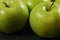 Green apples on black board - closeup photo with detail on skin texture