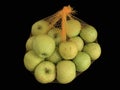 Green apples in a grid isolated on black. Ripe fruits in a string bag. Apples with face pattern. Concept: joy, happiness, positive Royalty Free Stock Photo