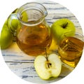 Green apples and jug with glass with apple juice on wooden background Royalty Free Stock Photo