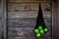 Green apples in a mesh bag hang on a wall lined with brown wood.