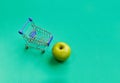 Green apples with mini shopping cart with green vintage color theme, instagram style, copy space or text space