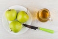 Green apples in plate, apple juice in jug and knife