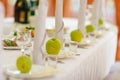 Green apples stand on empty plates on a table in restaurant Royalty Free Stock Photo
