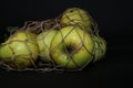 Green apples in a string bag, isolated on a black background. Food in an eco-friendly package Royalty Free Stock Photo