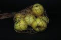 Green apples in a string bag, isolated on a black background. Food in an eco-friendly package Royalty Free Stock Photo