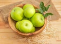 Green apples with twig in the vintage wooden fruit bowl Royalty Free Stock Photo