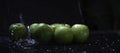 Green apples with water drops put on wet background