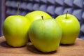 Green apples on a wooden table, grey patterned backdrop Royalty Free Stock Photo