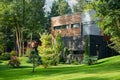 Green area. Modern wooden cottage house built in pine forest. Recreation, eco-friendly construction concept Royalty Free Stock Photo