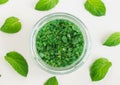 Green aroma bath salt foot soak in a glass jar and peppermint leaves. Natural beauty treatments.