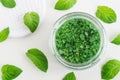Green aroma bath salt foot soak in a glass jar and peppermint leaves. Natural beauty treatments.