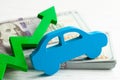 Green arrow graphic up on the background of the car and a stack of money cash dollars. The concept of the growth of the car market Royalty Free Stock Photo
