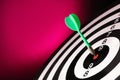 Green arrow hitting target on dart board against magenta background Royalty Free Stock Photo