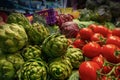 Green artichokes and red tomatoes at market Royalty Free Stock Photo