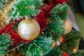 Green artificial Christmas tree decorated with beautiful golden ball with silver glitter, red and gold garlands, and other toys Royalty Free Stock Photo