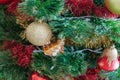 Green artificial Christmas tree decorated with beautiful golden sparking ball, red and gold garlands, and other toys Royalty Free Stock Photo