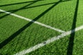 Green artificial grass football or soccer field with white line and goal net shadow background Royalty Free Stock Photo