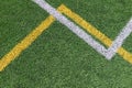 Green artificial grass turf soccer football field background with white and yellow line boundary. Top view Royalty Free Stock Photo