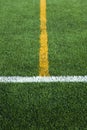 Green artificial grass turf soccer football field with white and yellow line boundary Royalty Free Stock Photo