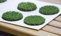 Green artificial turf rolled. Probes examples of artificial turf, floor coverings for playgrounds. Selective focus Royalty Free Stock Photo