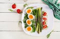 Green asparagus with boiled eggs and sandwich cream cheese on a white plate. Royalty Free Stock Photo